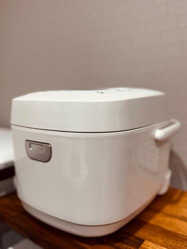 a white rice cooker sitting on a wooden table at Niseko Purr 101 in Kutchan