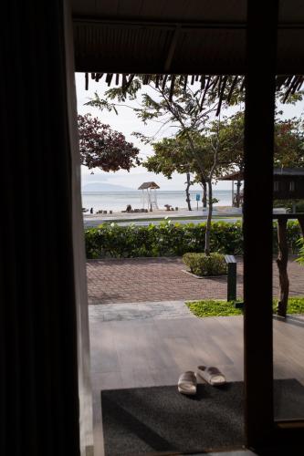 a view of a beach from a room with shoes at Crusoe Cabins Casobe in Calatagan