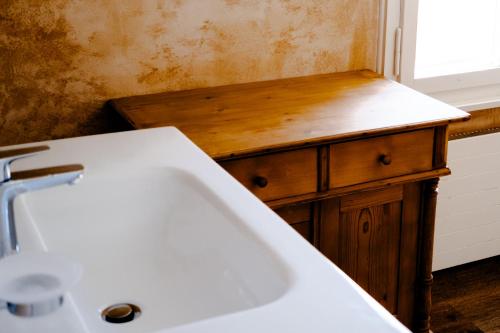a bathroom with a white sink and a wooden counter at Drei Könige in Entlebuch