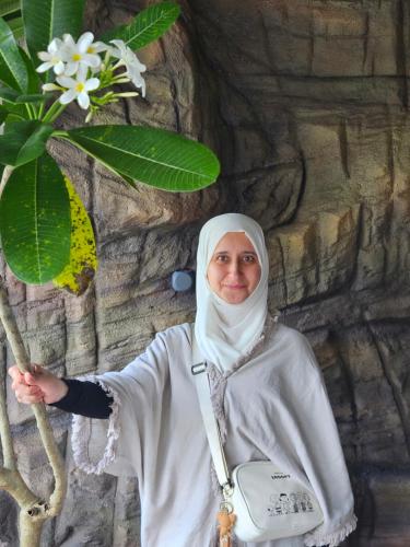 a nun standing in front of a stone wall at S & B Dreams House in Munnar