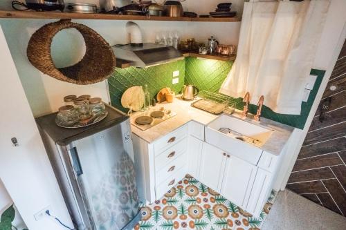 a small kitchen with white cabinets and a sink at UMI Nest Apartment in Subic Bay with Self-Serve Breakfast - WiFi, Bathtub, Barbecue, Pet Friendly with a Fee in Santa Rita