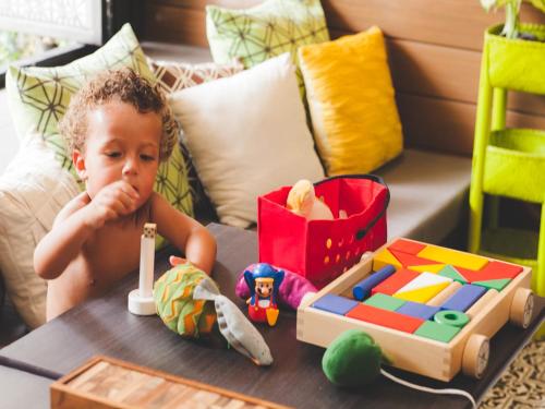 a young child sitting at a table with toys at Ploen Chaweng by Tolani in Chaweng