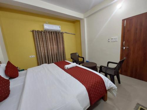 a bedroom with a bed and a table and chairs at Manor Residency in Varanasi