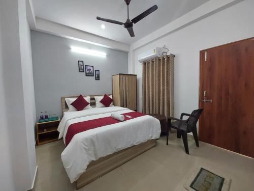 a bedroom with a large bed and a chair at Manor Residency in Varanasi