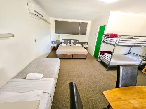 a room with two bunk beds and a table at Green Door Motel in Albury