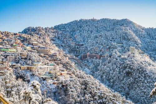 a city on a mountain covered in snow at Sejal Homestay in Shimla