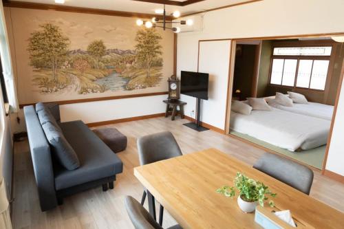 a room with a bed and a table and chairs at 青い池まで車で20分Biei Breeze Reserve in Biei
