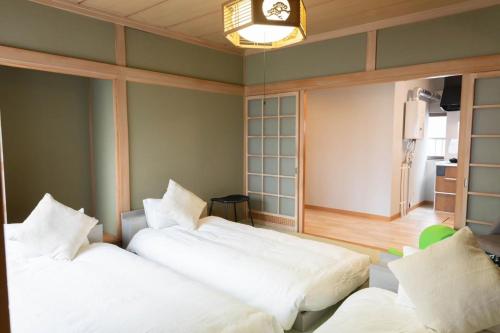 two beds in a room with green walls at 青い池まで車で20分Biei Breeze Reserve in Biei
