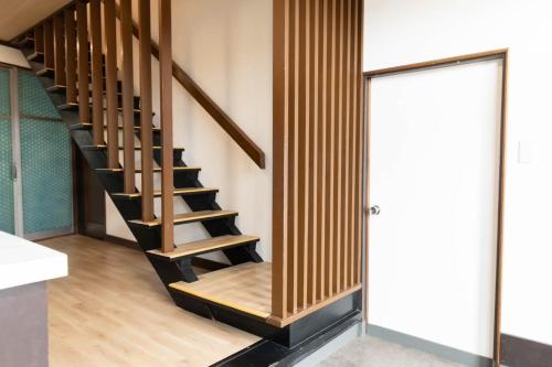 a wooden staircase in a room with a door at 青い池まで車で20分Biei Breeze Reserve in Biei