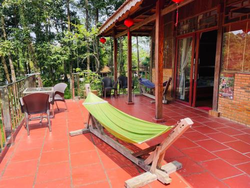 a hammock on a patio of a house at Cát Tiên Riverside in Tân Phú