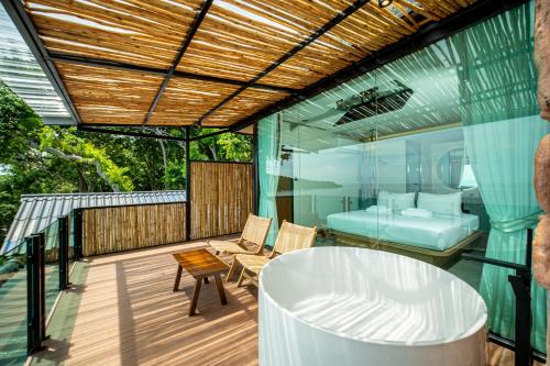 a balcony with a tub and a bedroom at Sangthian Beach Resort in Ko Samed