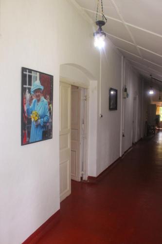 a hallway with a painting of a man on a wall at HEYCOCK CEYLON HlLL in Gampola