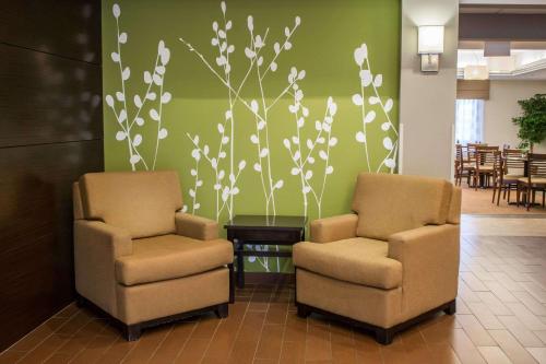 two chairs in a lobby with a wall with flowers at Sleep Inn & Suites Harbour Pointe in Brandermill