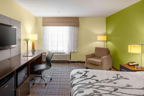 a hotel room with a bed and a desk and a chair at Sleep Inn & Suites Harbour Pointe in Brandermill