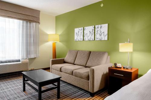 a hotel room with a couch and a bed at Sleep Inn & Suites Harbour Pointe in Brandermill