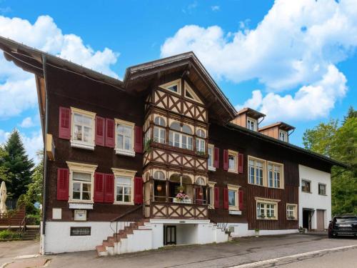 a large building with red shutters on a street at Chalet in Sibratsgfäll near Ski Slopes in Sibratsgfäll