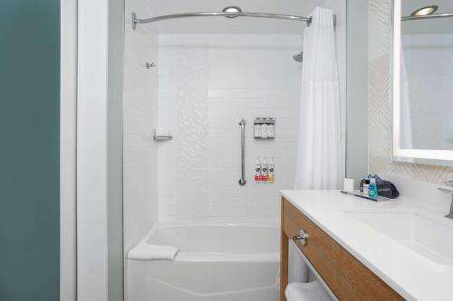 a white bathroom with a tub and a shower at Wyndham Grand Clearwater Beach in Clearwater Beach