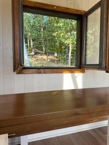 a wooden bench in a room with a window at Maringotka u Krkavčích skal in Křižany