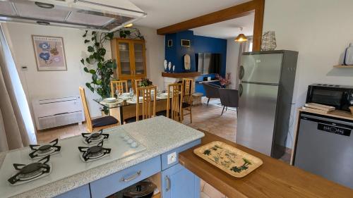 Il comprend une cuisine équipée d'un réfrigérateur et une salle à manger. dans l'établissement Les Marguerites, à Bornel