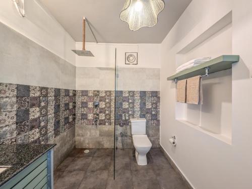 a bathroom with a toilet and a glass shower at Beach Villa Morjim in Morjim