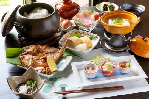 un tavolo ricoperto di piatti di cibo su un tavolo di Natural Hot Spring Inn Choseian - 長生庵 - a Shirahama