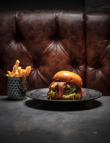 a plate with a sandwich and french fries on a table at Castle Hotel in Taunton