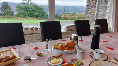 a table with a plate of bread and a bowl of cheese at B&B Kerry Lakesview Lodge in Waterville