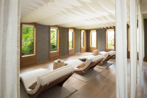 a row of white beds in a room with windows at Conrad Bora Bora Nui in Bora Bora