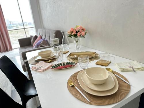 a table with plates and bowls and a vase with flowers at Уютный уголок в престижной части города 3 in Bishkek
