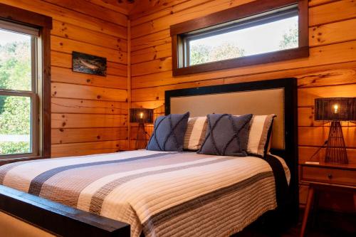 a bedroom with a bed in a log cabin at NEW BUILD Toccoa River Mist Riverfront Property w Hot Tub Firepit More in Blue Ridge