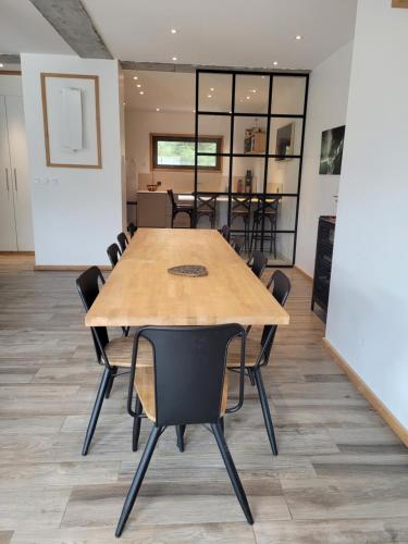 une salle de conférence avec une table et des chaises en bois dans l'établissement Maison Serre Chevalier, à Briançon