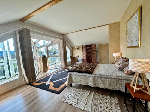une chambre avec un grand lit et de grandes fenêtres dans l'établissement Chalet Victoire, à Gérardmer