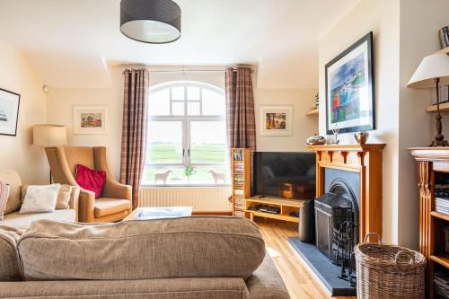 a living room with a couch and a fireplace at 10 Ballaghmore Cottages in Portballintrae