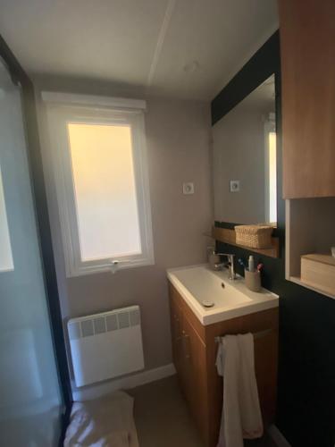 a bathroom with a sink and a window at Mobile home cocon in Lège-Cap-Ferret