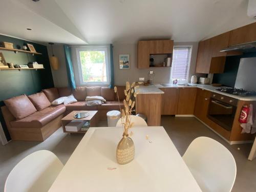 une cuisine et un salon avec une table et des chaises dans l'établissement Mobile home cocon, à Lège-Cap-Ferret