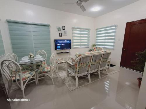 a living room with a table and chairs and a television at Vacation Home near Panglao Airport and White Sand Beaches in Biking