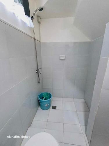 a bathroom with a toilet and a blue bucket at Vacation Home near Panglao Airport and White Sand Beaches in Biking
