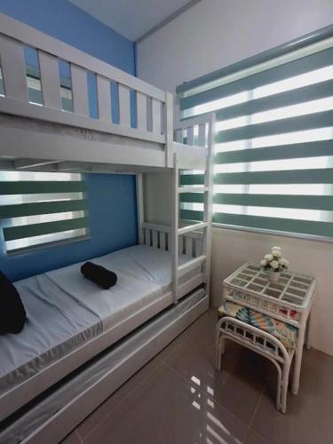 a bedroom with two bunk beds and a table at Vacation Home near Panglao Airport and White Sand Beaches in Biking