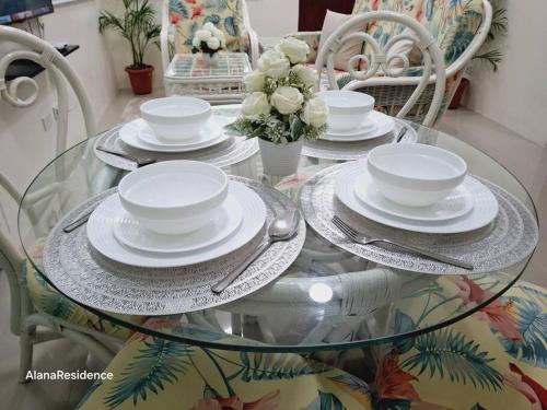 a glass table with plates and dishes on it at Vacation Home near Panglao Airport and White Sand Beaches in Biking
