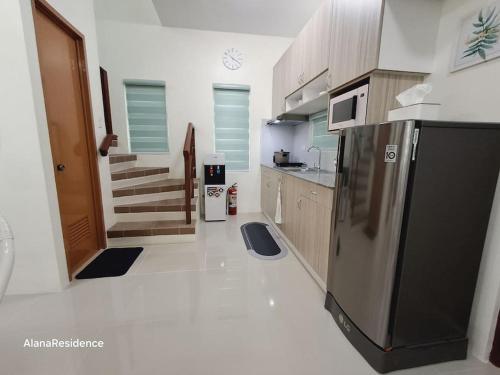 a kitchen with a stainless steel refrigerator and cabinets at Vacation Home near Panglao Airport and White Sand Beaches in Biking