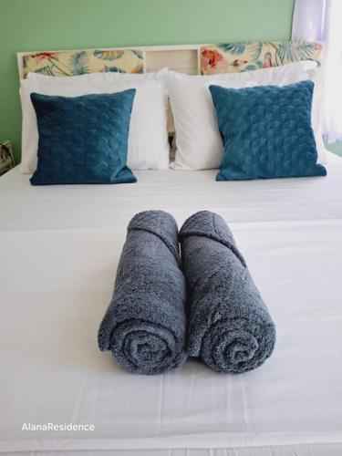 two rolled towels sitting on top of a bed at Vacation Home near Panglao Airport and White Sand Beaches in Biking