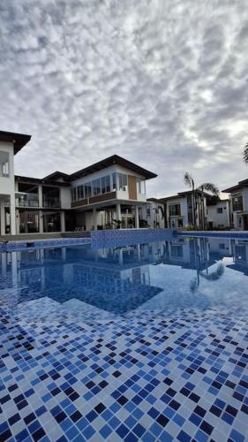 a large swimming pool with blue tiles in front of a building at Vacation Home near Panglao Airport and White Sand Beaches in Biking