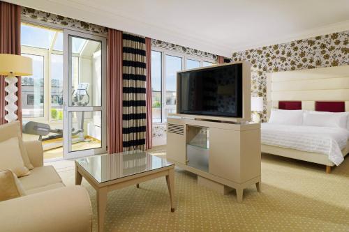 a bedroom with a bed and a television in a room at Le Méridien Stuttgart in Stuttgart
