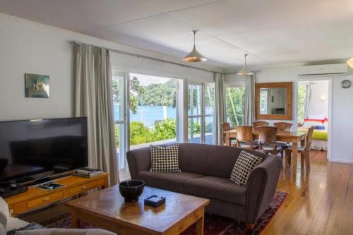 a living room with a couch and a table at LAST ON THE STRAND, RUSSELL - The BOATHOUSE in Russell