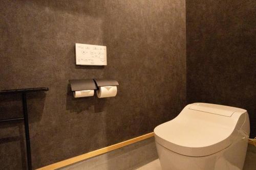 a bathroom with a toilet and two rolls of toilet paper at 糸島STAYｘCafe 海のみちひき-小富士あたり- in Itoshima