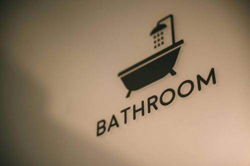 a logo on a wall with the name of a bathroom at 糸島STAYｘCafe 海のみちひき-小富士あたり- in Itoshima