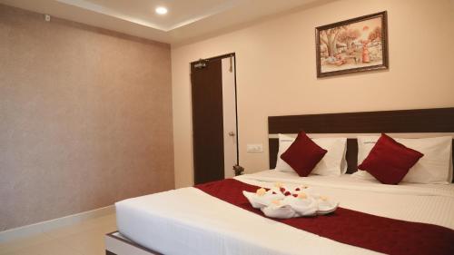 a hotel room with two beds with red pillows at Hotel Mountview Comforts in Tirupati