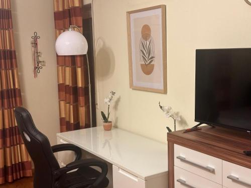 a room with a desk with a television and a chair at Tabita 2, with 3 sleeping rooms in Untermeitingen