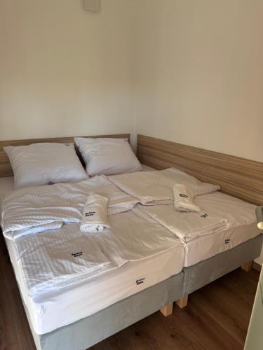 a bed with white sheets and pillows on it at Apartament w Dolinie Sanu Lesko in Lesko