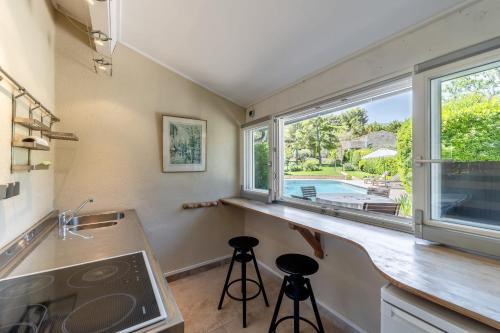 une cuisine avec un comptoir, un évier et une fenêtre dans l'établissement Li Cigalo, à Bonnieux